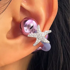 Detalle de clip de auricular de estrella de mar con circonitas en auricular lila