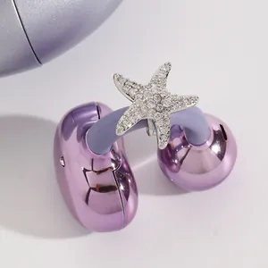 Vista detallada de un amuleto de estrella de mar con pedrería para auriculares inalámbricos