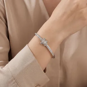 Detailed macro view of an elegant silver bangle set with sparkling pavé zircons on a wrist