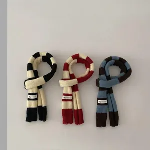 Vista dettagliata di tre accessori a maglia a righe per bambini in nero, rosso e blu