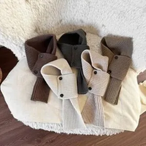 Dettaglio dei mini borselli decorativi in maglia per bambini in vari colori naturali