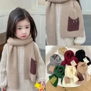 Vista dettagliata della sciarpa in maglia per bambini con tasca a forma di orecchie di gatto.