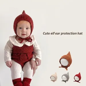 Vista dettagliata di un neonato che indossa un cappello da elfo lavorato a maglia rosso