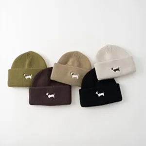 Primo piano dettagliato di berretti in maglia per bambini in cinque colori con ricamo cane.
