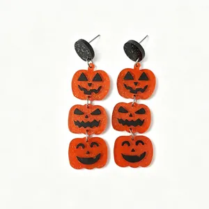Halloween acrylic tiered pumpkin earrings with glitter black studs on white background