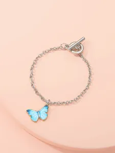 Detailed view of silver chain bracelet with blue butterfly charm and OT toggle clasp.