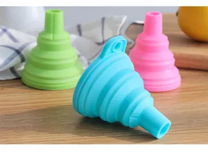 Vue détaillée de trois entonnoirs pliables en silicone colorés sur une table en bois
