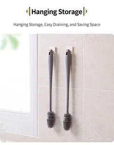Close-up of two long gray silicone bottle brushes hanging on wall hooks to save space
