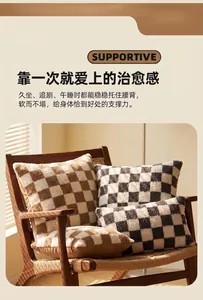Close-up of checkered sherpa pillowcases in brown and grey on a wooden chair