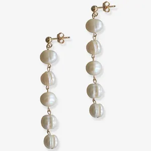 Dettaglio di orecchini pendenti con perle barocche naturali e placcatura oro 18K