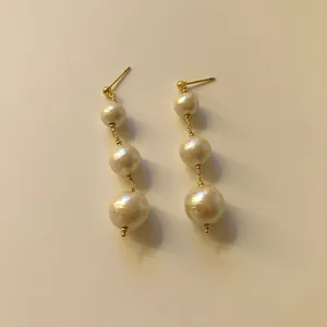 Eleganti orecchini a goccia in oro con tre perle d'acqua dolce naturali, vista ravvicinata