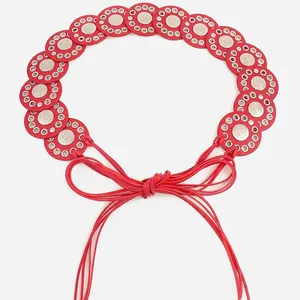 Detail view of red Bohemian belt featuring linked metal discs and tie-knot cord closure.