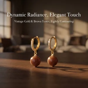 Detail of gold-plated hoop earrings with zircons and brown semi-precious stone pendants
