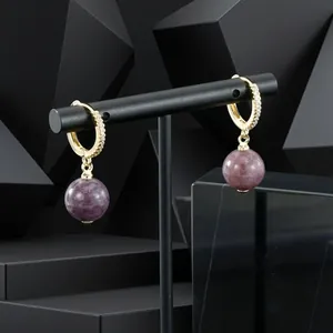 Detail showing gold plated zircon hoop earrings with purple semi-precious stone drops