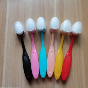 Détail de six pinceaux de maquillage colorés en forme de brosse à dents avec étuis.