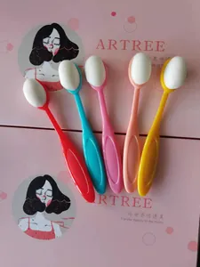 Vue rapprochée de cinq pinceaux à fond de teint ovales colorés de type brosse à dents