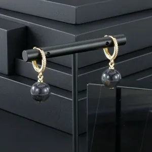 Close-up of gold-plated hoop earrings with cubic zirconia and semi-precious stone drops