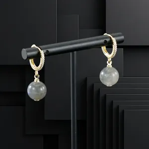 Detailed close-up of gold-plated zircon hoop earrings with grey semi-precious stone drops