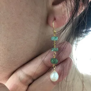 Gros plan détaillé de boucles d'oreilles vintage avec perles vertes et perle d'eau douce