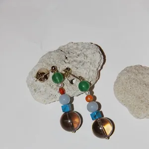 Vue détaillée de boucles d'oreilles élégantes avec pierres naturelles et perles