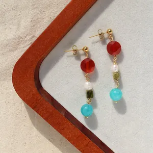 Gros plan de boucles d'oreilles rétro avec pierres naturelles et perles d'eau douce.