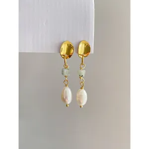 Vue détaillée de boucles d'oreilles dorées avec pierre naturelle et perles baroques