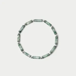 Primer plano de cuentas cilíndricas de piedra natural verde y separadores de plata