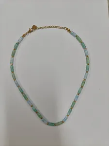 Detalle de cuentas de piedra natural verde y azul claro con espaciadores dorados