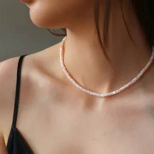Primo piano di una collana di perline rettangolari in conchiglia naturale su una modella