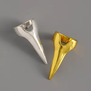 Macro detail showing gold and silver metallic pointed claw nail rings for fashion