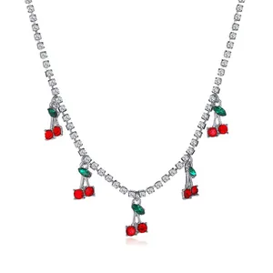 Detailed macro view of elegant silver-tone cherry necklace with red and green gemstones