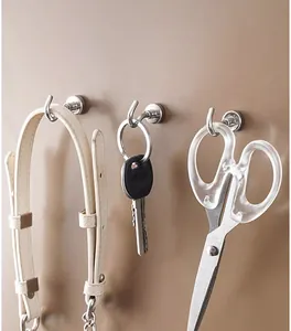 Strong metal magnetic hooks holding keys and scissors shown in a detailed close-up view.