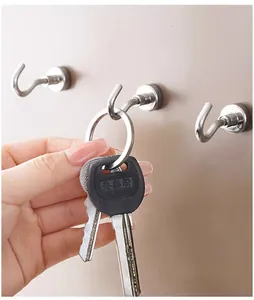 Detailed close-up shot of a durable silver magnetic metal hook holding a keyring on a wall