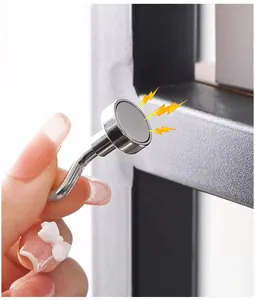 Close-up showing the strong magnetic suction of the silver metal hook on a black frame