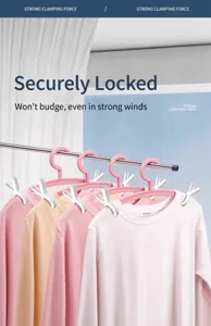 Detailed close-up of strong white windproof laundry clips securing shirts on pink hangers.