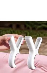 Close-up of white heavy-duty quilt clips holding a pink duvet outdoors