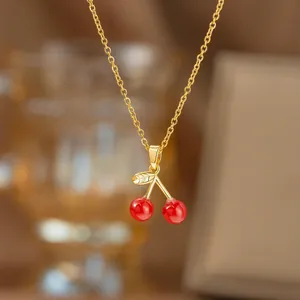 Elegante Goldhalskette mit rotem Kirschanhänger, stilvolles Accessoire.