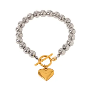 Pulsera elegante de cuentas de acero con colgante de corazón dorado y cierre de T.