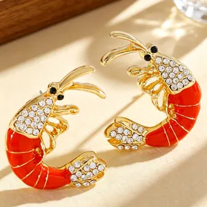 Close-up detail of red enamel lobster stud earrings with sparkling crystal accents