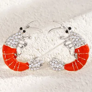 Close-up of vibrant red enamel lobster earrings featuring sparkling clear rhinestones