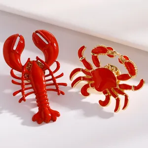 Detaillierte Makroansicht von roten Emaille-Ohrringen mit Hummer und Krabbe für den Strand