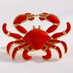 Macro view of a vibrant red enamel crab pendant with gold-tone alloy details for women.