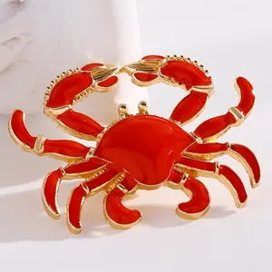 Detailed macro shot of a vibrant red enamel crab pendant with gold-tone alloy accents