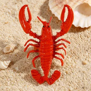 Macro detail of a bright red alloy lobster ring placed on a tropical sandy beach
