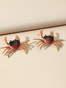 Macro detail view of realistic ocean-themed crab earrings with gradient enamel finish