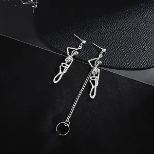 Detailopname van vintage punk skelet oorbellen met zilveren ketting en oormanchet