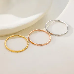 Detailed macro view of three minimalist water ripple rings in gold, rose gold, and silver