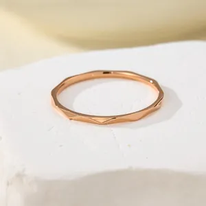 Macro detail of the rose gold water ripple titanium steel ring on a white stone base