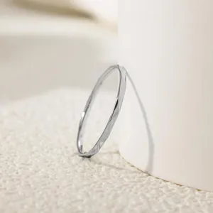 Detail view of a minimalist silver titanium steel ring with water ripple texture.