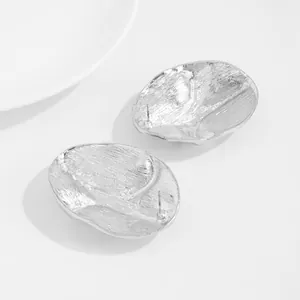 Close-up of silver irregular wrinkled metal petal stud earrings showing back detail